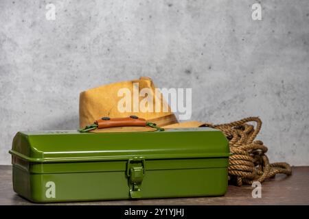 Old straw hat, green tool box and rope on a work bench with room for copy Stock Photo