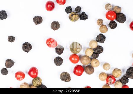Red, green, white and black peppercorns on a white background macro top view Stock Photo