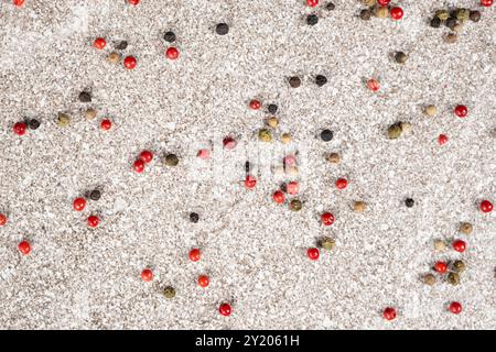 Multicolored peppercorns on a stone gray background. Stock Photo