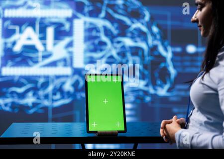 Engineer uses AI machine learning to extract information from complex data on green screen tablet. Woman in workspace uses artificial intelligence technology on mockup device, close up Stock Photo