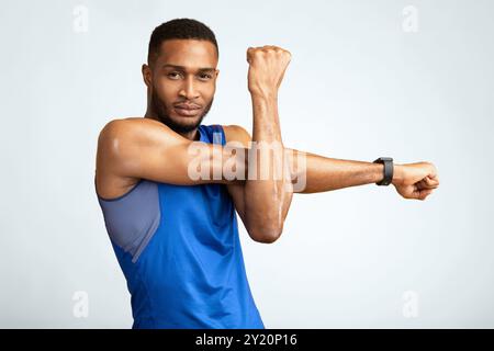 Healthy black guy stretching hand and shoulder before workout Stock Photo