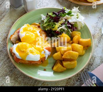 Portion of eggs benedict toast with salmon and potatoes closeup Stock Photo