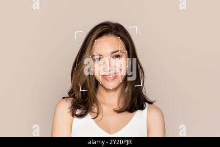 Smiling woman with facial recognition overlay against a neutral background Stock Photo