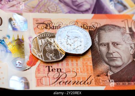 Close-up of British coins and banknotes featuring King Charles III, focusing on the new currency designs, including a 50-pence coin and 10-pound note. Stock Photo