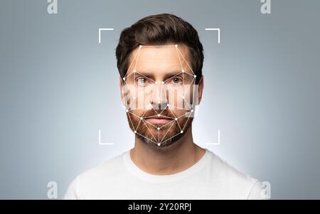 Man with facial recognition grid on his face against a gray background Stock Photo