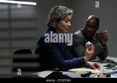 Two business professionals engaged in an intense discussion in a corporate setting. One person attentively listening while the other explaining a point, showcasing collaboration and strategy Stock Photo