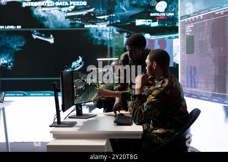 Team of military professionals in control center monitors satellite ...