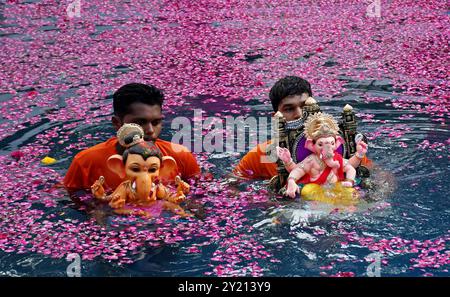 Volunteers carries idols of elephant-headed Hindu god Ganesh for immersion in an artificial pond in Mumbai. Idols of elephant-headed Hindu god Ganesh is traditionally immersed in a water body like lake, river or ocean, smaller idols are immersed in  artificial man made ponds across the city. The ritual is done to signify the birth cycle of Lord Ganesha Stock Photo