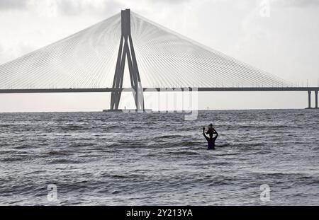 A volunteer carries idol of elephant-headed Hindu god Ganesh for immersion at Arabian sea in Mumbai. Idols of elephant-headed Hindu god Ganesh is traditionally immersed in a water body like lake, river or ocean, smaller idols are immersed in  artificial man made ponds across the city. The ritual is done to signify the birth cycle of Lord Ganesha Stock Photo