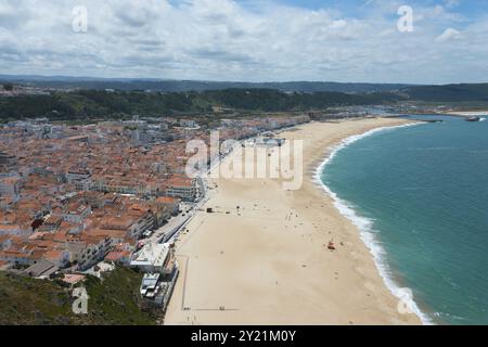 Beach with city in the background and extensive coastline, blue sea and soft clouds in the sky, view from Sitio to the lower town, Sitio, Nazare, Na Stock Photo