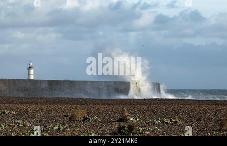 Lighthouse at Newhaven with waves breaking over harbour arm Stock Photo