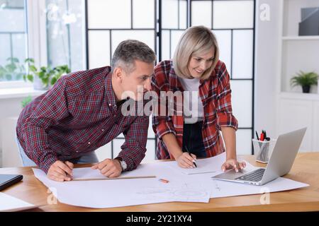 Architects making engineering drawing at wooden table in office Stock Photo