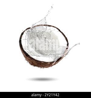 Fresh coconut water splashing from nut in air on white background Stock Photo