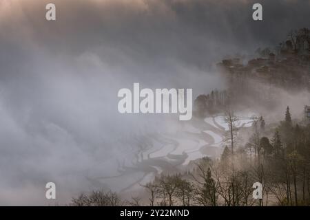 Sea of clouds covering the small village of Duoyishu and the UNESCO rice fields, Yunnan, China. Copy space for text Stock Photo