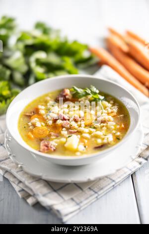 Soup made from barley groats, smoked pork neck, potatoes and root vegetables. Stock Photo