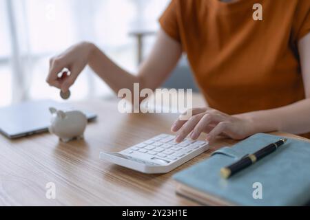 woman creates a detailed financial saving plan using a calculator to organize her expenses and ensure long-term financial stability and security. Stock Photo