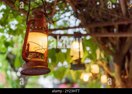 Row of old street lights on green foliage background Stock Photo