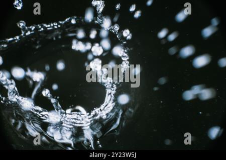 Splashes of blue clear water in motion on a black background closeup Stock Photo