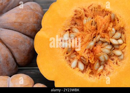 Close-up of an orange-coloured nutmeg pumpkin. The pumpkin is photographed from above. It is cut open in the centre and you can see the seeds and the Stock Photo