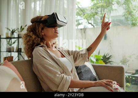 Woman Using VR Glasses At Home Stock Photo