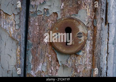 Old rusty lock mounted on old wooden door cracked by time Stock Photo