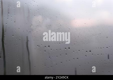 City view through a window on a rainy day.Rain falls on the window glass. Stock Photo