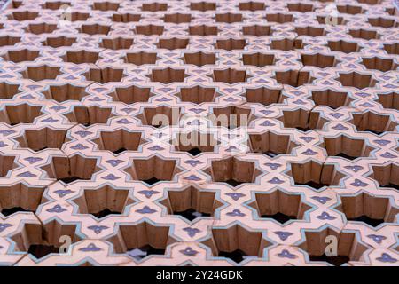 The image is of a patterned wall with a lot of holes in it Stock Photo
