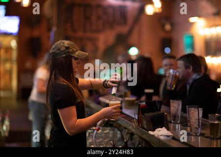 Bar tender pouring beer behind bar Stock Photo