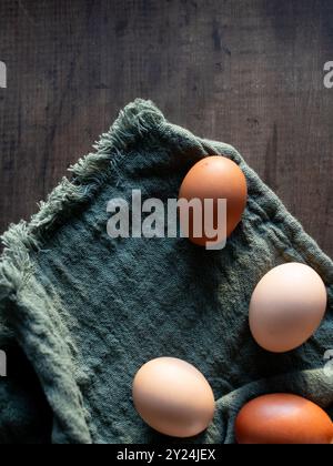 Brown eggs on green fabric with wooden background in soft light Stock Photo