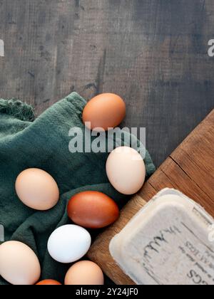 Brown and white eggs on green fabric beside carton Stock Photo