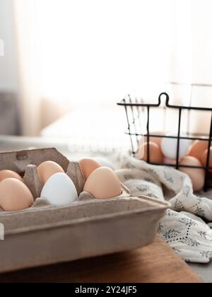 Brown and white eggs in a carton and wire basket on a soft fabric Stock Photo