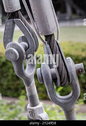 Steel wire rope slings with Thimble and safety anchor shackle turnbuckle connection bolt for heavy work. Metal ring and Steel cabling attached to a sh Stock Photo