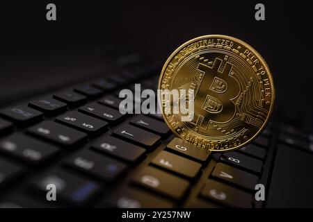Bitcoin gold coins on futuristic and abstract background over black laptop keyboard. Finance and investment concept. Stock Photo