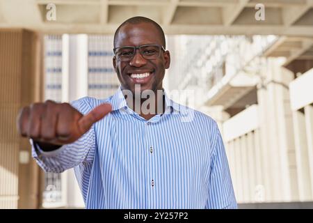 Confident Businessman Giving Thumbs Up Outdoors in City Stock Photo
