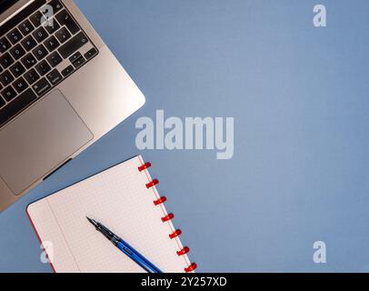 A flat lay composition featuring a red notebook, fountain pen, laptop, and mouse on a desk, representing modern workspace essentials for productivity Stock Photo