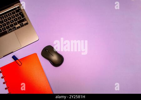 A flat lay composition featuring a red notebook, fountain pen, laptop, and mouse on a desk, representing modern workspace essentials for productivity. Stock Photo