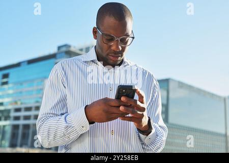 Businessman Using Smartphone Outdoors in Urban Cityscape Stock Photo
