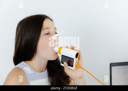 Girl testing breathing function by spirometry in doctors office ...