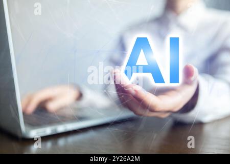 A person is holding a laptop and the word AI is displayed on the screen Stock Photo