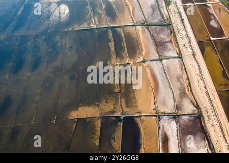 Salt pans with seawater for sea salt production on Pag Island. Divided basins for evaporating process under hot sun and wind in Croatia Stock Photo