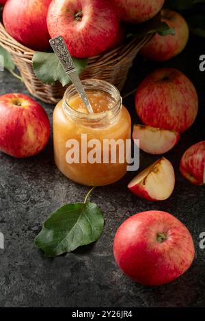 Apple jam and red fresh apples on a black stone table. Stock Photo