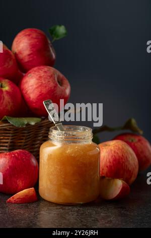 Apple jam and red fresh apples on a black stone table. Stock Photo