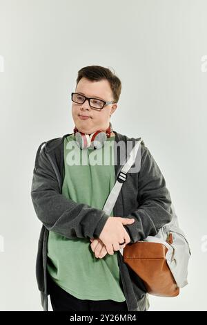 Cheerful young man with Down syndrome enjoying his time at home with headphones and a backpack. Stock Photo