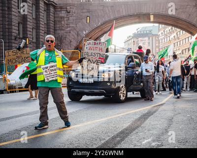 Stockholm, Sweden - September 7 2024: A public protest supporting Palestine and opposing Zionism on Kungsgatan. A man holding signs that read 'Israel Stock Photo