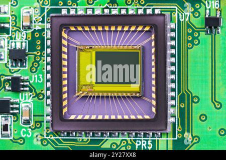 Closeup of image sensor on printed circuit board inside digital camera. Small die and gold wires of integrated chip in transparent package from imager Stock Photo
