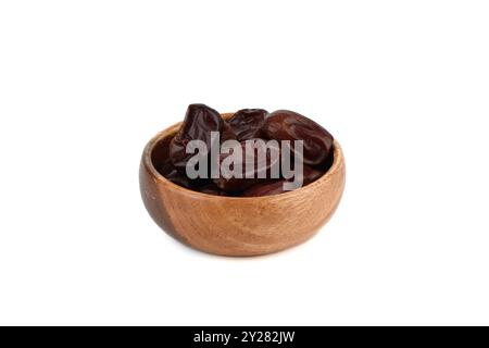 Dehydrated date fruits in wooden bowl on white background. Copy space. Stock Photo