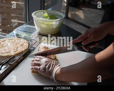 The cook cuts the flatbread with salmon. Quesadilla.  Stock Photo