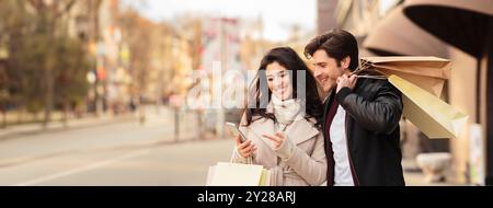 Order taxi online. Couple using smartphone after shopping Stock Photo