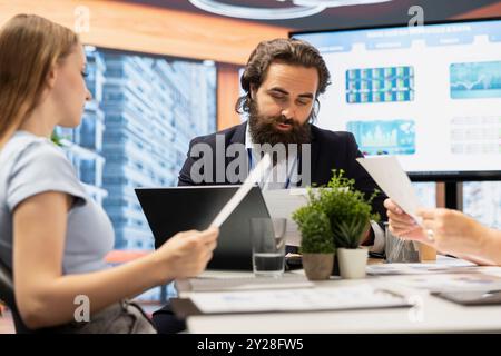 Portfolio Manager in office meeting analyzing economic reports, discussing with teenager wanting to receive student loan. Financial advisor helping young adult fund her education Stock Photo