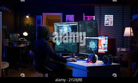 Hacker running artificial intelligence spyware software designed to gather information from users computers without their knowledge. Scammer commits fraud using AI, camera B Stock Photo